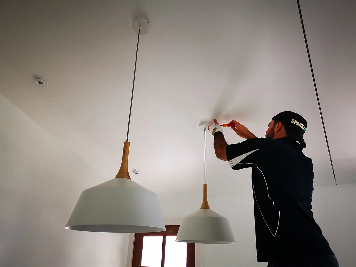 Electrician in a Sparky 4 You cap fitting white pendant lights in a new build
