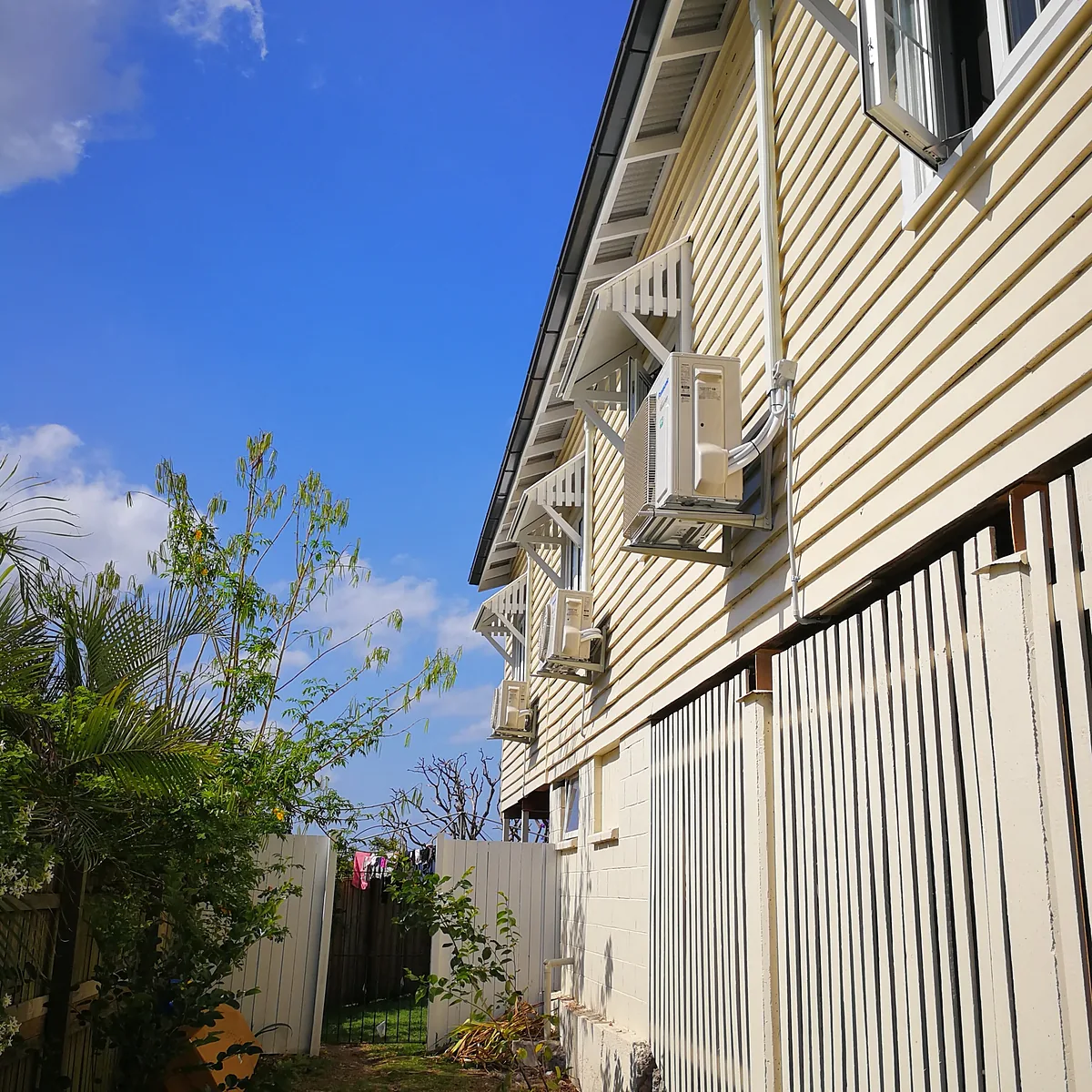 Timber Queenslander house with split system air conditioning units mounted on the side wall