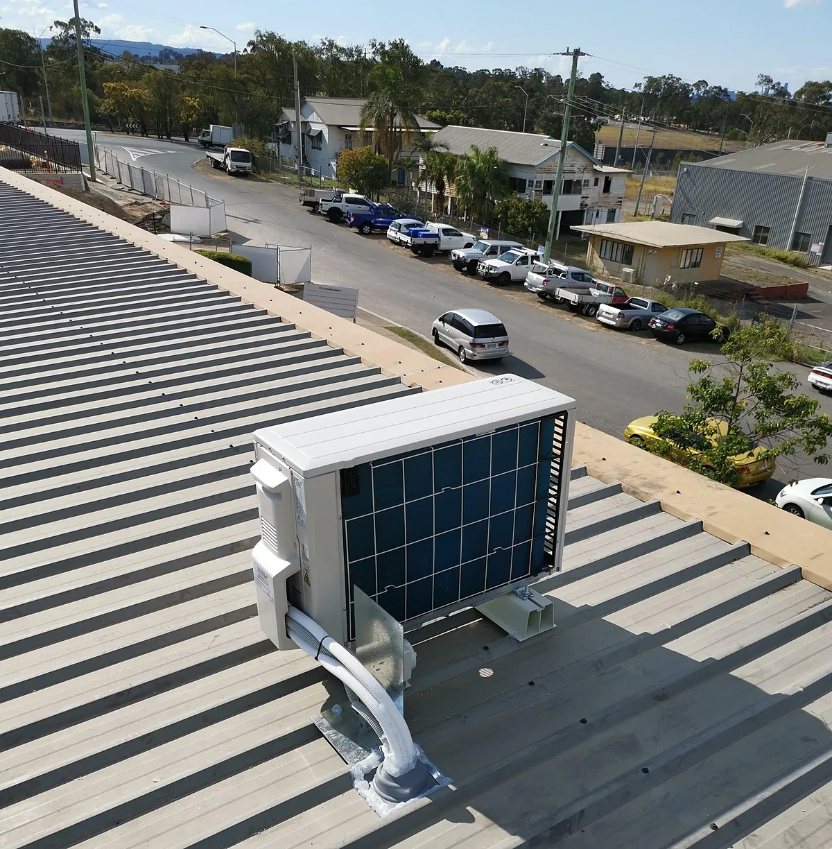 Split system condenser mounted on a commercial roof overlooking the street